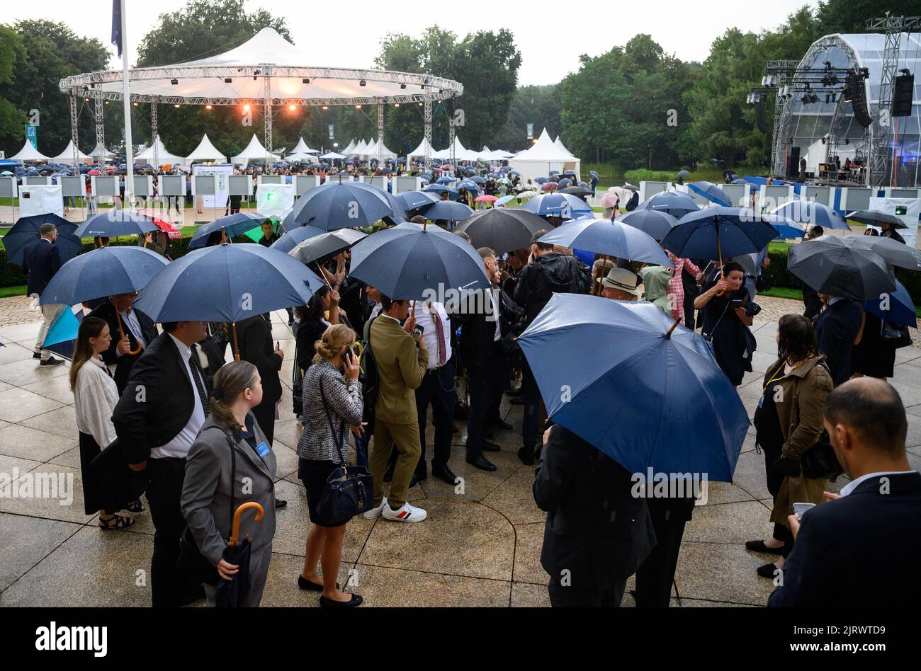 Berlin, Allemagne. 26th août 2022. Les invités essaient d'engager une conversation avec le président Steinmeier et sa femme sous des parasols au Festival des citoyens du président fédéral dans le parc du palais de Bellevue. Le festival, auquel près de 1 500 bénévoles ont été invités, met l'accent sur l'importance de l'engagement civique pour une société civile forte. En raison d'un fort orage sur Berlin, le président Steinmeier et sa femme ont annulé vendredi soir le festival de leurs citoyens pour des raisons de sécurité. Credit: Bernd von Jutrczenka/dpa/Alamy Live News Banque D'Images