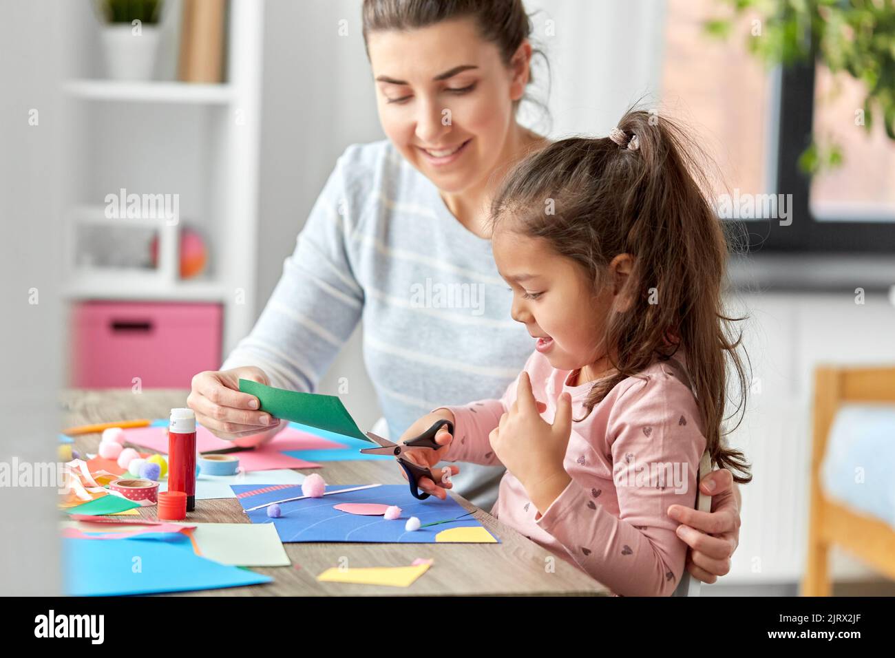 fille avec mère faisant l'application à la maison Banque D'Images