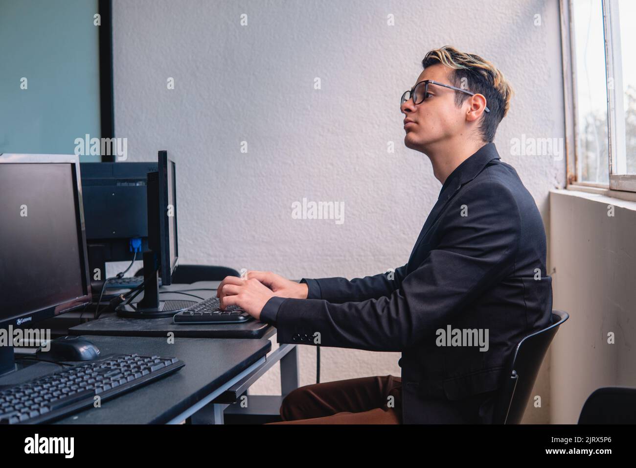 Un employé de bureau travaillant sur son ordinateur au bureau. Un  travailleur intelligent sur son ordinateur de bureau. Programmeur  travaillant avec de nombreux ordinateurs. Photo de haute qualité Photo  Stock - Alamy