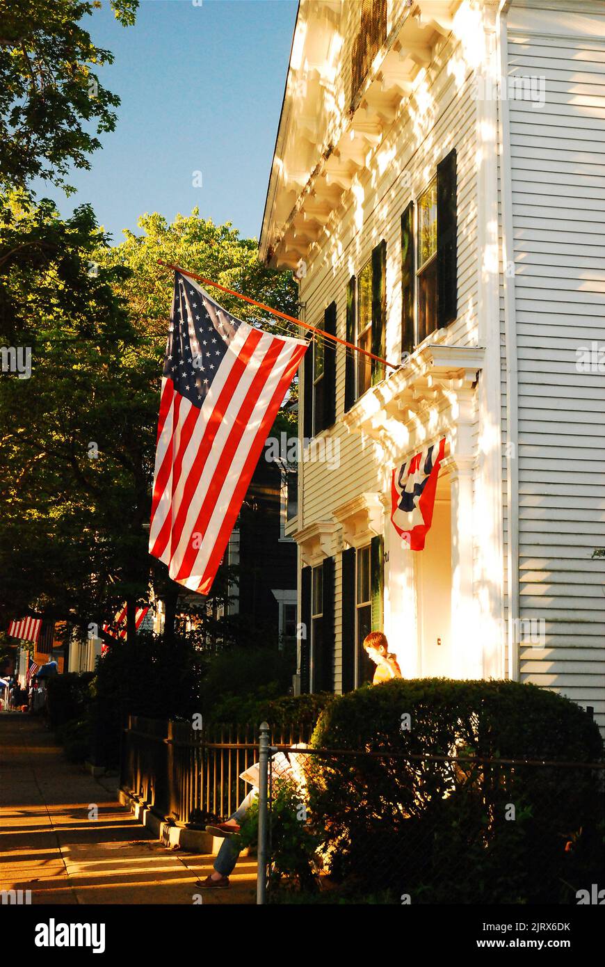 Un drapeau américain survole la façade d'une maison de banlieue lors des vacances du 4 juillet Banque D'Images