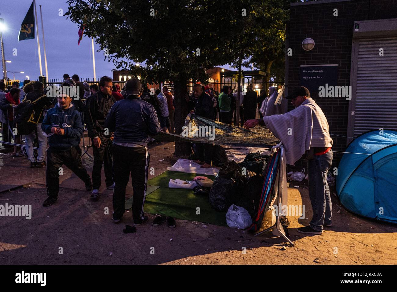 Ter Apel, pays-Bas. 26th août 2022. 2022-08-26 20:57:58 TER Apel - les demandeurs d'asile cherchent un abri de la pluie devant la porte du centre d'application surpeuplé de Ter Apel. Au cours des dernières nuits, 700 personnes ont dormi à l'extérieur du centre d'applications parce qu'il n'y a pas assez d'espace. Le gouvernement se hâte de mettre fin au chaos. ANP VINCENT JANNINK pays-bas - belgique sortie crédit: ANP/Alay Live News Banque D'Images