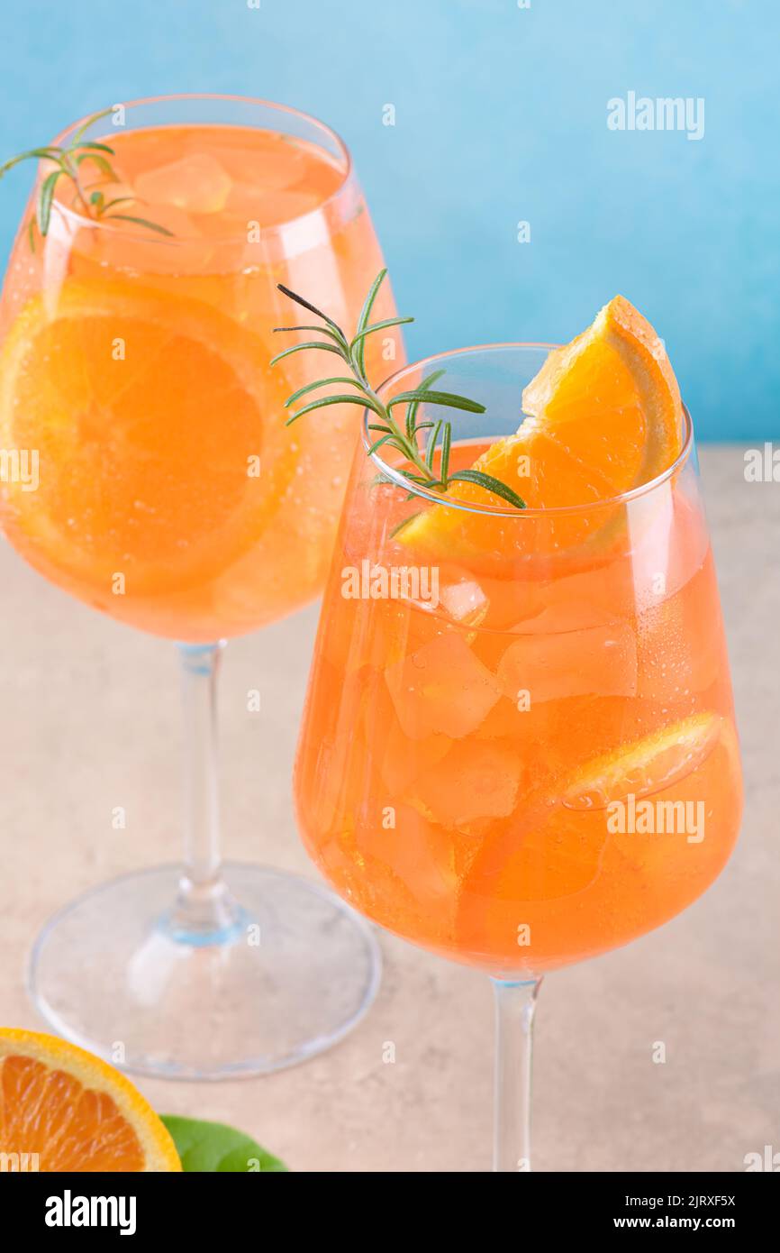 Apéritif italien classique apéritif aperol spritz dans deux verres avec glace, orange sur fond bleu sur podium en marbre Banque D'Images