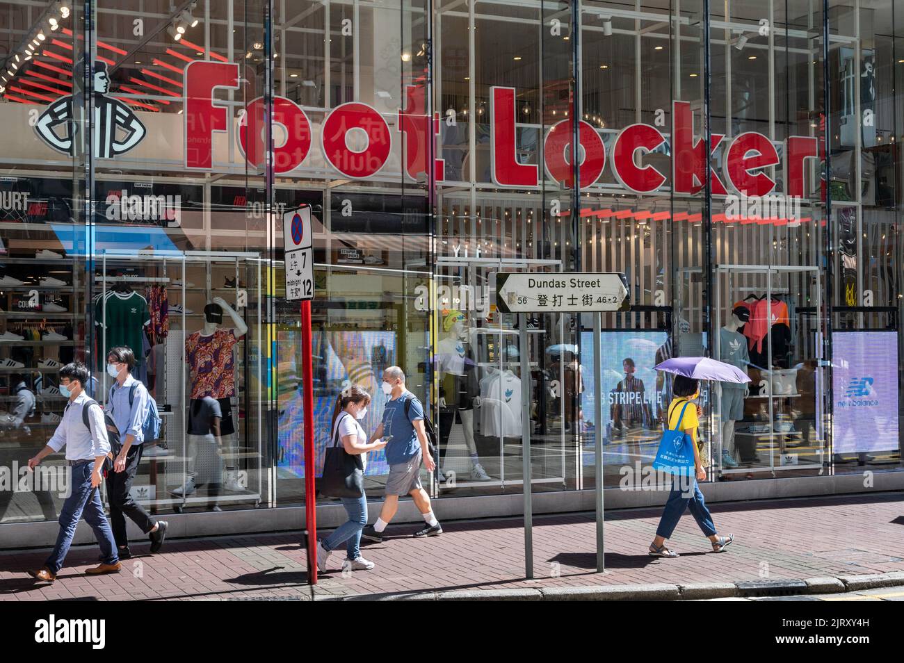 Les acheteurs se prominent devant le détaillant américain de vêtements de sport et de chaussures multinational, le magasin foot Locker à Hong Kong. Banque D'Images