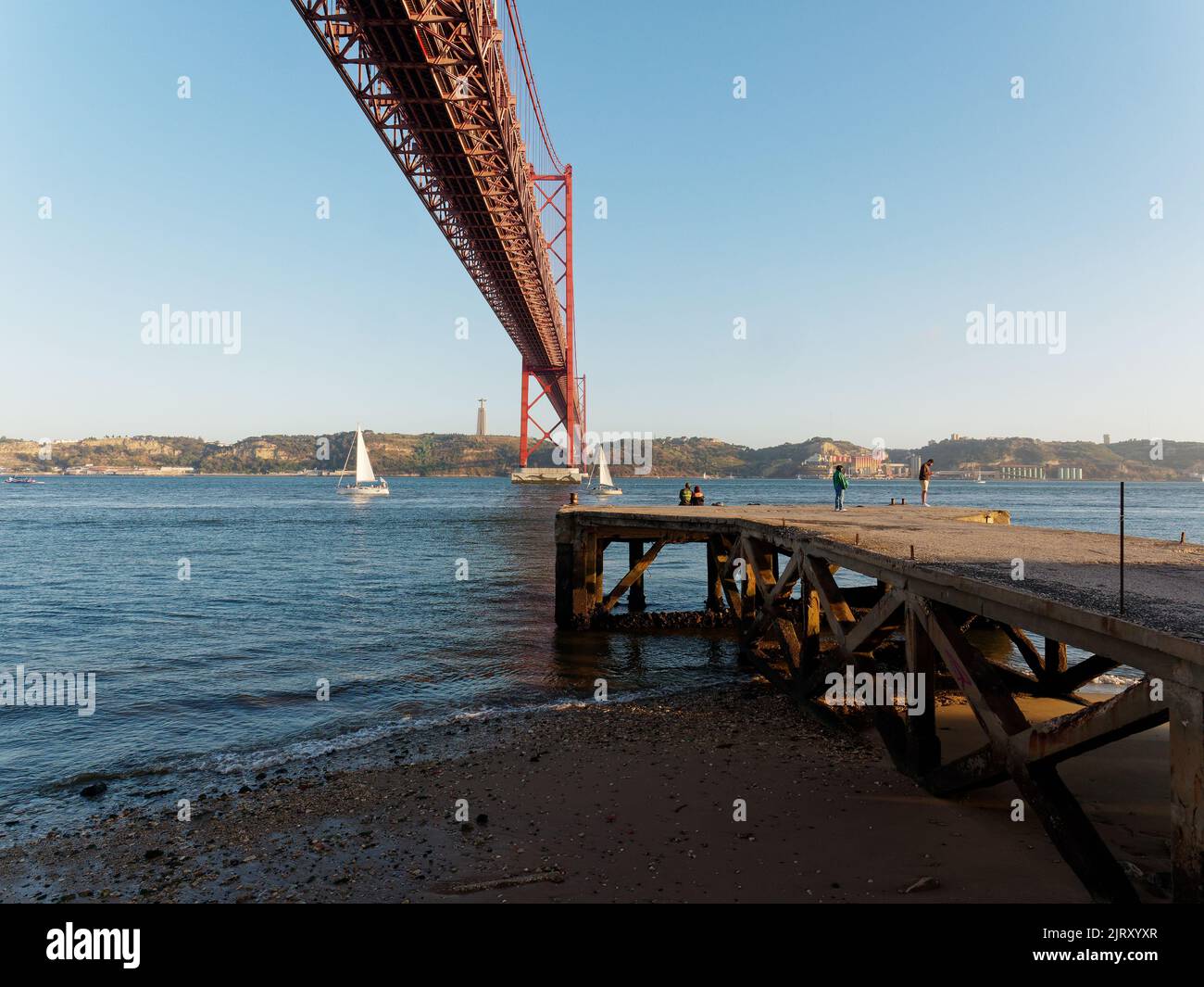 Le Ponte 25 de Abril (pont du 25th avril) enjambant le Tage à Lisbonne, Portugal. Jetée et plage au premier plan. Banque D'Images