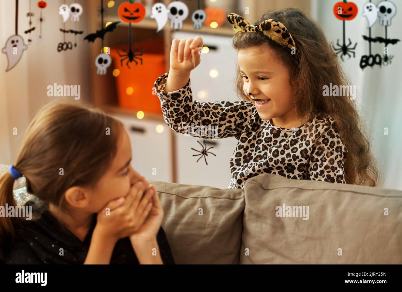 filles en costumes d'halloween jouant avec l'araignée Banque D'Images