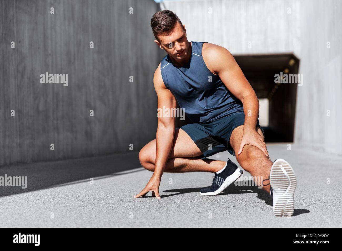 homme faisant du sport et s'étirant des jambes à l'extérieur Banque D'Images
