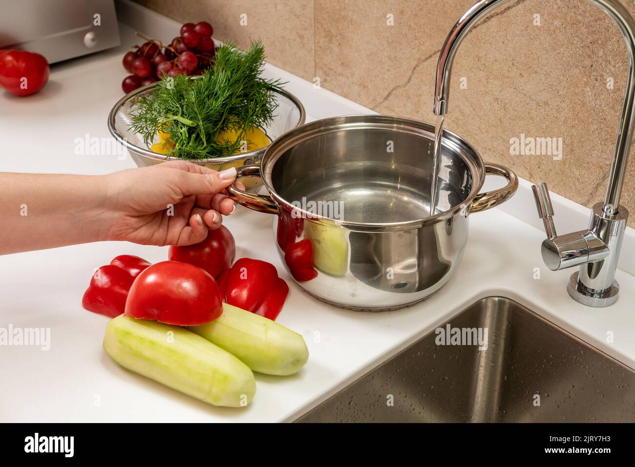 De l'eau pure filtrée s'écoule dans le pot pour une soupe future Banque D'Images