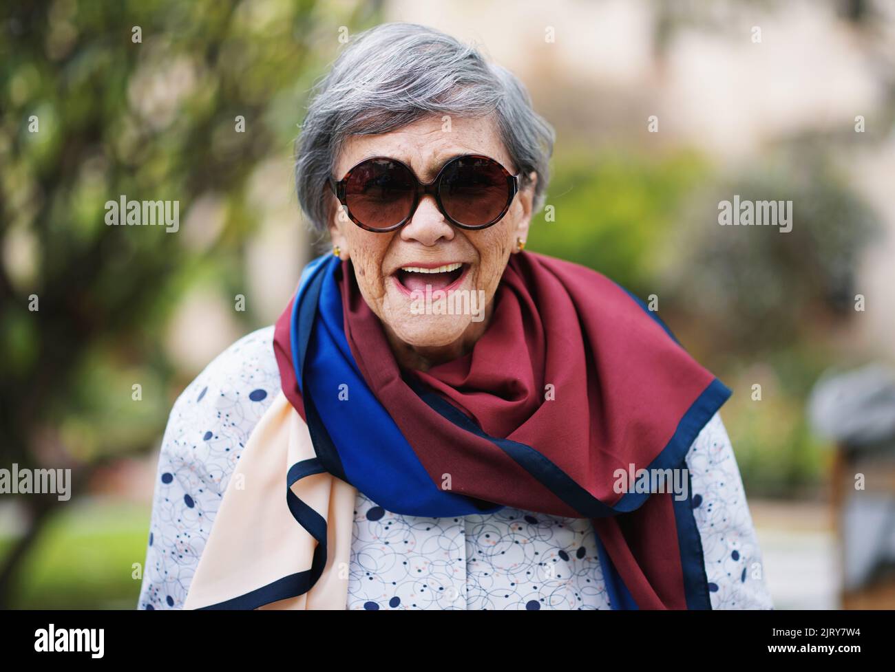 Portrait d'une vieille femme heureuse en train de rire en portant des lunettes de soleil Banque D'Images