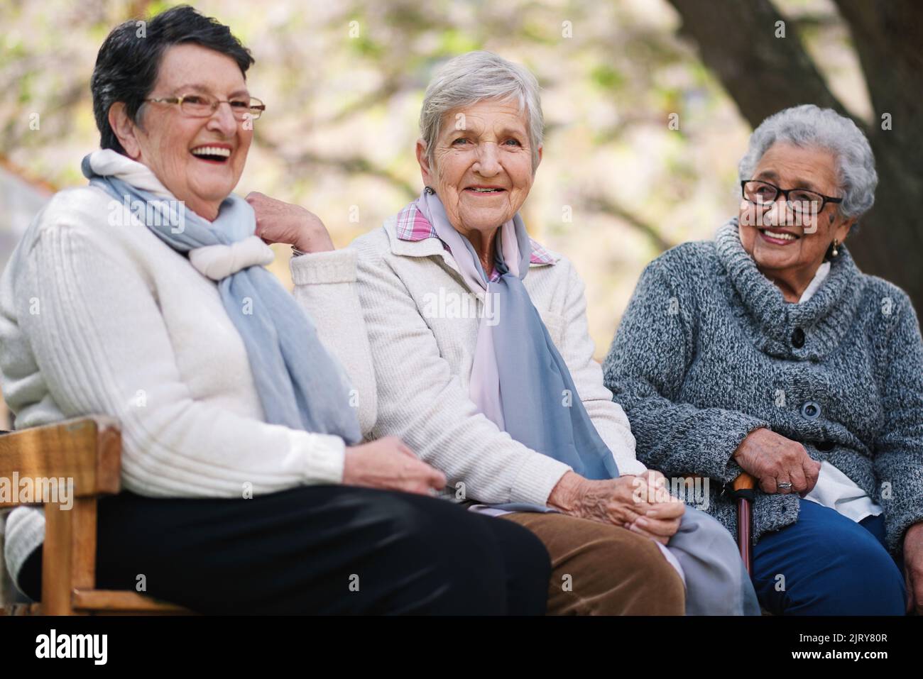 De vieilles femmes heureuses assis sur le banc dans le parc souriant heureux vie longue amis appréciant la retraite ensemble Banque D'Images