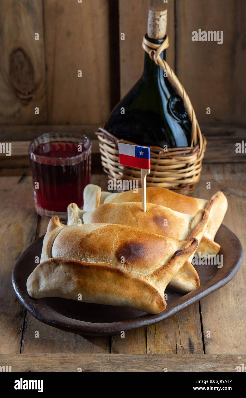 Concept de jour de l'indépendance chilienne. Fiestas patrias. Typique empanadas de pino cuit au four, vin ou chicha, chapeau et jouer incarnant. Plat et boisson le 18 septembre Banque D'Images