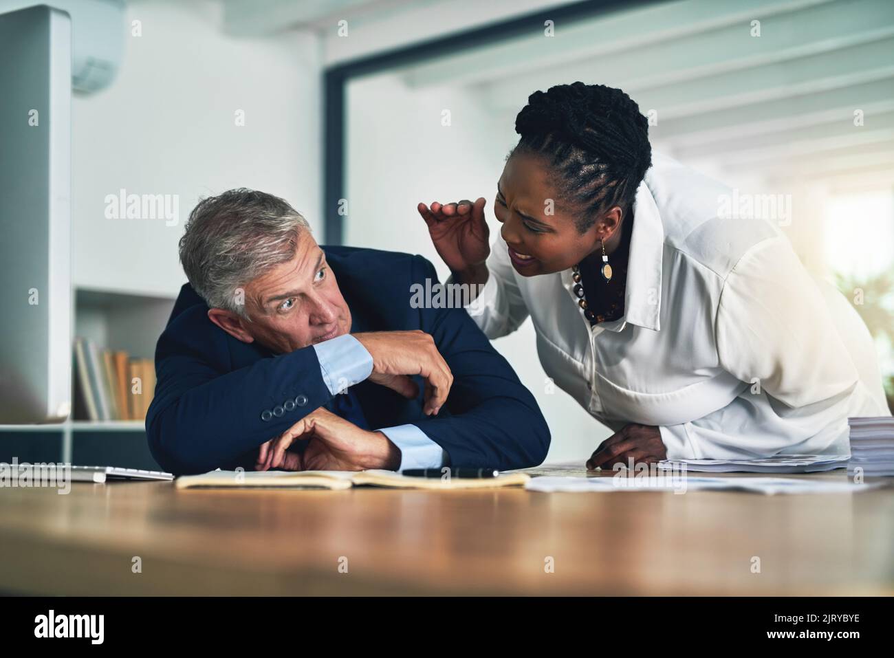 Ne me laissez pas vous prendre à nouveau. Une femme d'affaires réveillant son collègue alors qu'il dort à son bureau. Banque D'Images