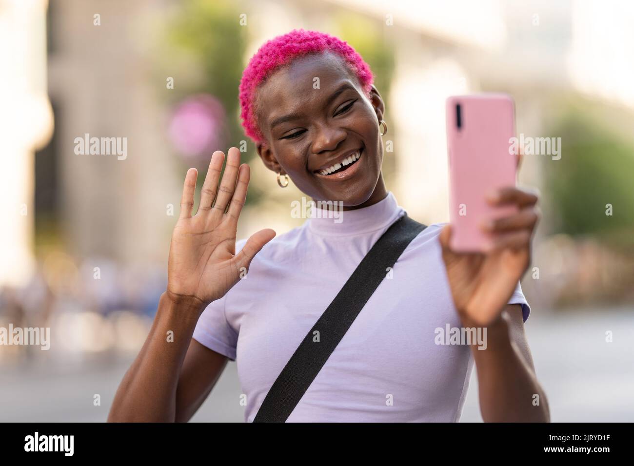 Jeune femme africaine agitant à l'extérieur mobile Banque D'Images