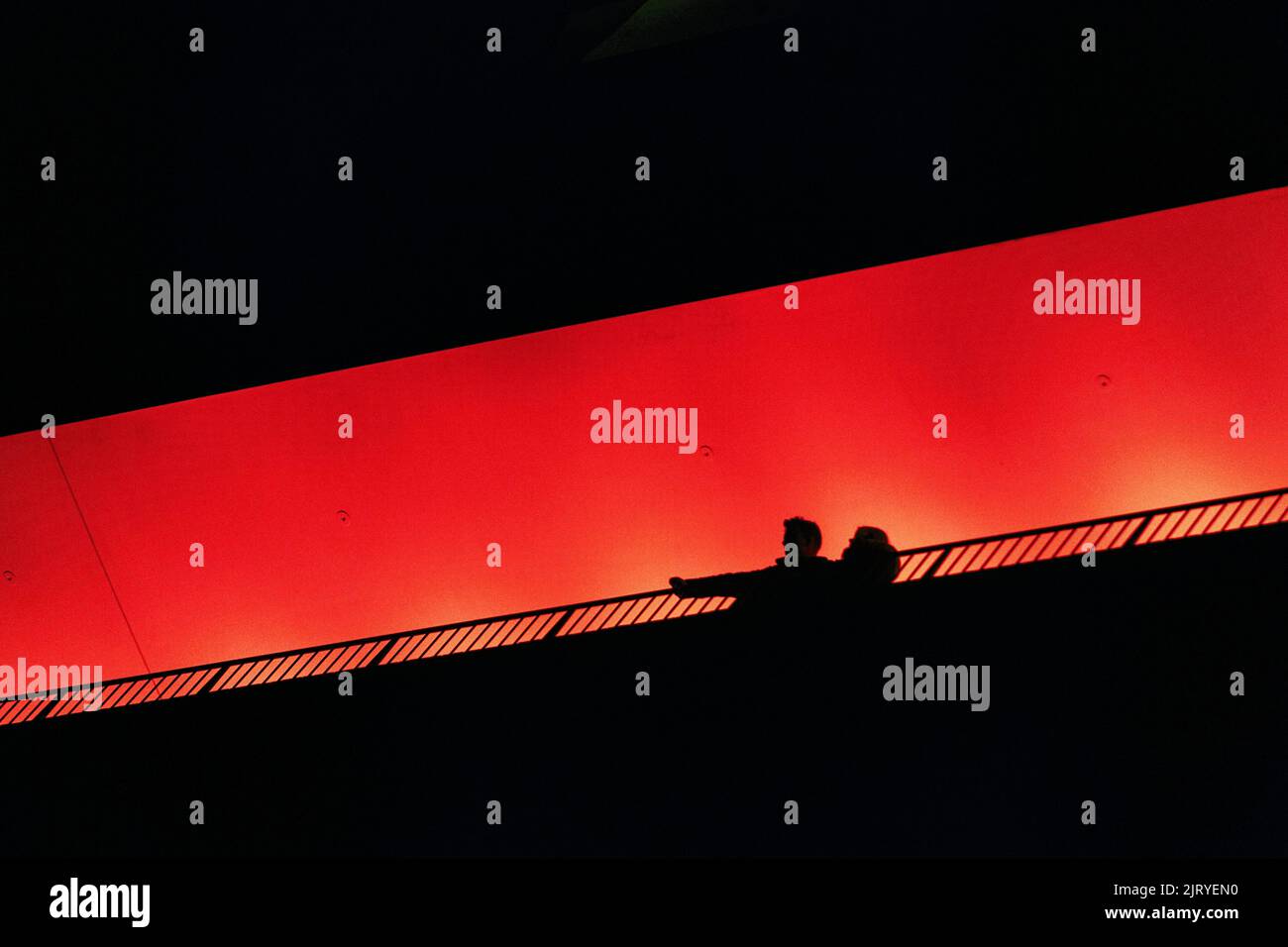 Deux personnes, couple debout sur la terrasse d'observation Plaza, en regardant vers le bas, silhouettes dans l'obscurité, orange illuminé, salle philharmonique d'Elbe dans le Banque D'Images