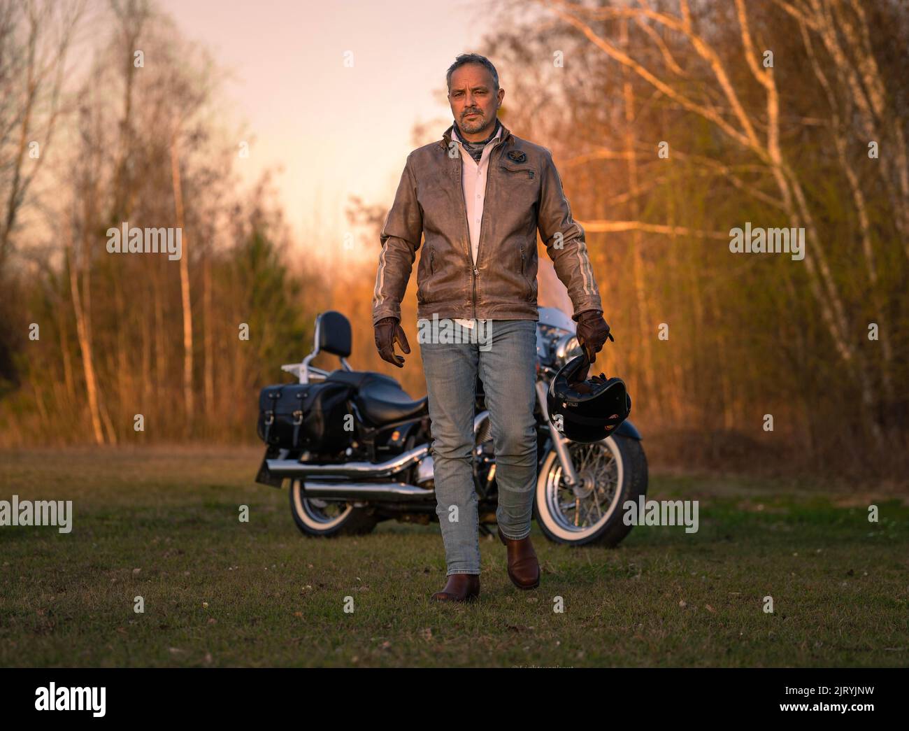 Homme d'âge moyen en cuir veste court héroïquement loin de moto, Karlsruhe, Allemagne Banque D'Images