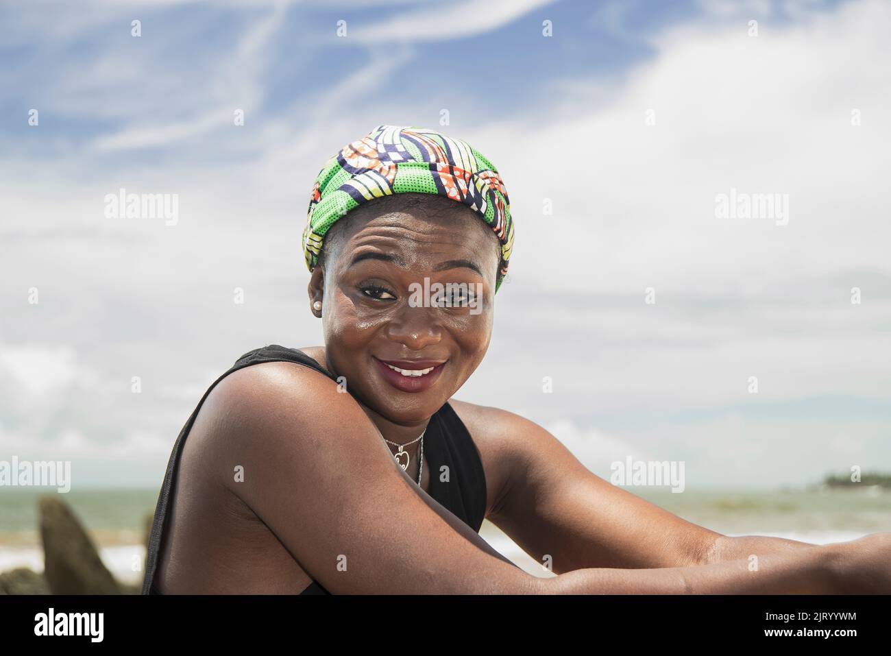 Bonne femme africaine avec headaddress du Ghana sur une plage sur la côte de l'Axim Ghana Afrique de l'Ouest Banque D'Images