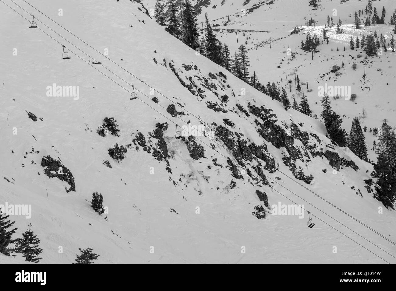 Un télésiège se déplaçant au-dessus de la falaise couverte de neige dans une station de ski près du lac Tahoe en Californie Banque D'Images