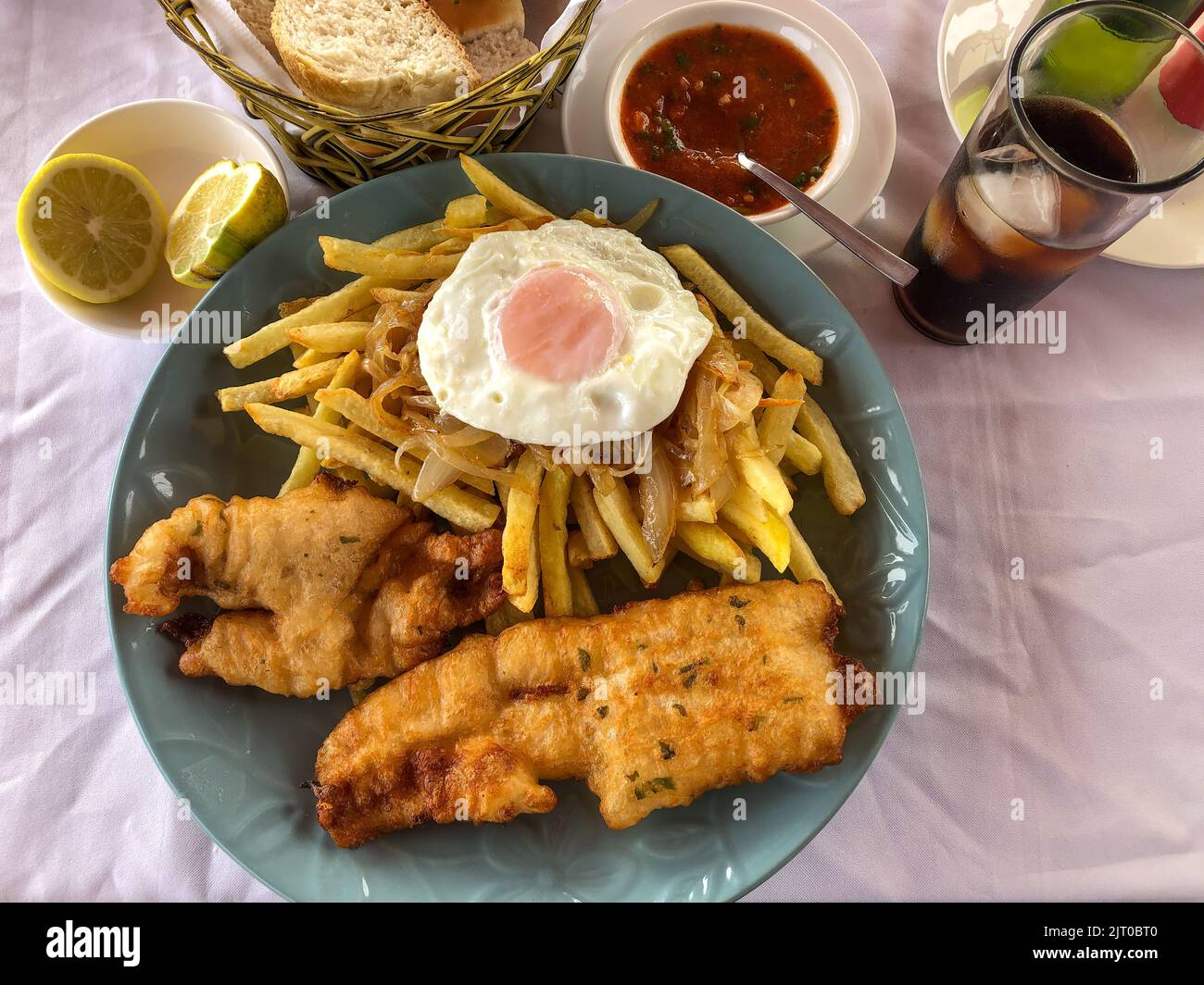 Pesca a lo pobre ou Poor Man's Fish avec un œuf frit et des oignons sur des frites sur la plage à Caleta Pan de Azucar, Chili. Banque D'Images