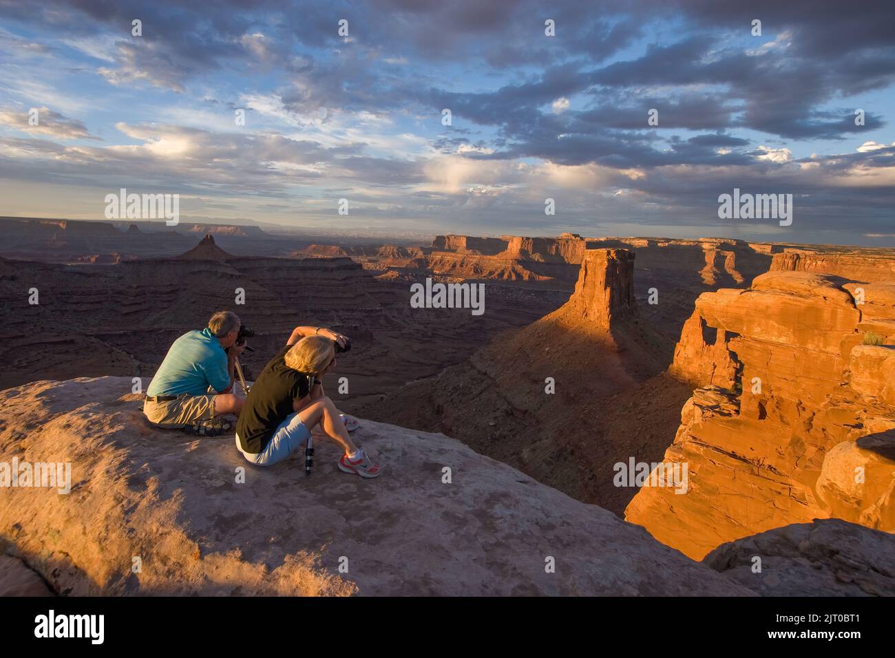 Deux photographes prennent des photos d'un paysage à Marlboro point au lever du soleil dans les canyons près de Moab, Utah. Banque D'Images