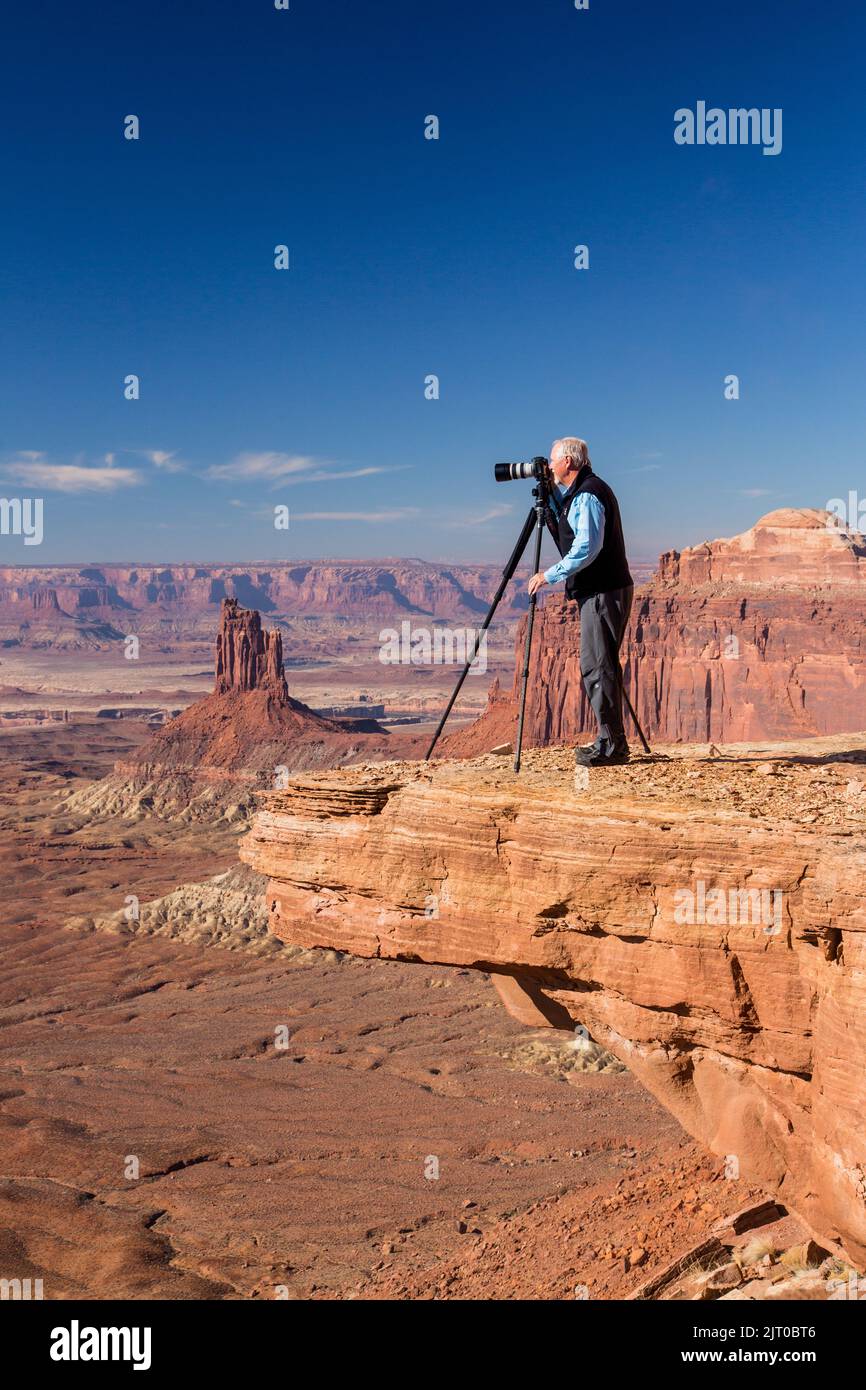 Photographe paysagiste prenant une photo d'un rocher suspendu dans le parc national de Canyonlands, près de Moab, Utah. Banque D'Images
