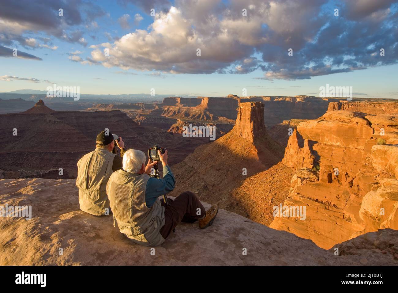Deux photographes prennent des photos d'un paysage à Marlboro point au lever du soleil dans les canyons près de Moab, Utah. Banque D'Images