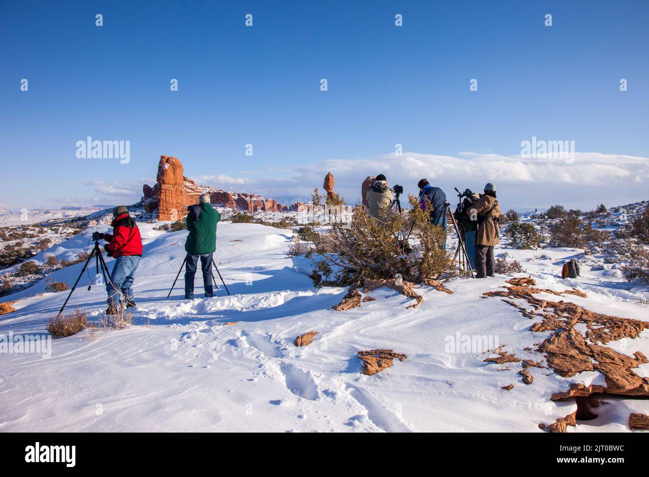 Un groupe de photographes dans un atelier de photo prenant des photos dans le parc national d'Arches près de Moab, Utah en hiver. Banque D'Images
