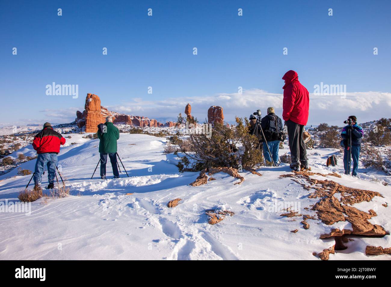 Un groupe de photographes dans un atelier de photo prenant des photos dans le parc national d'Arches près de Moab, Utah en hiver. Banque D'Images