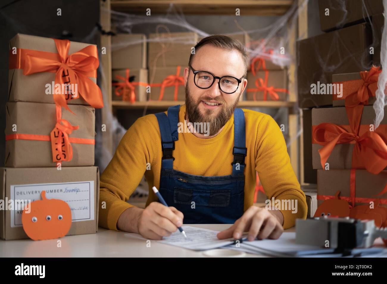 Un mâle dropshipping propriétaire de petite entreprise prenant l'ordre. Employé d'entrepôt, vendeur. Grande vente de rabais et de promotions de biens en l'honneur de Halloween. Banque D'Images