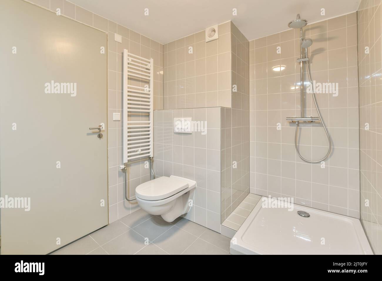 Design intérieur élégant de la salle de bains avec toilettes blanches et baignoire avec douche en verre dans un appartement moderne Banque D'Images