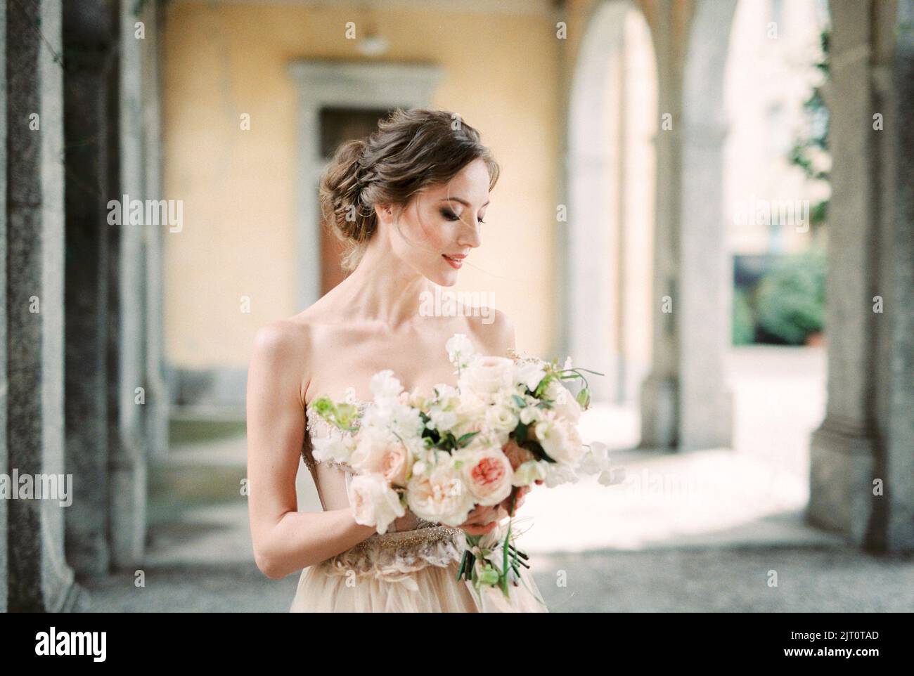 Mariée avec un bouquet de fleurs dans ses mains sur la terrasse avec des arches Banque D'Images