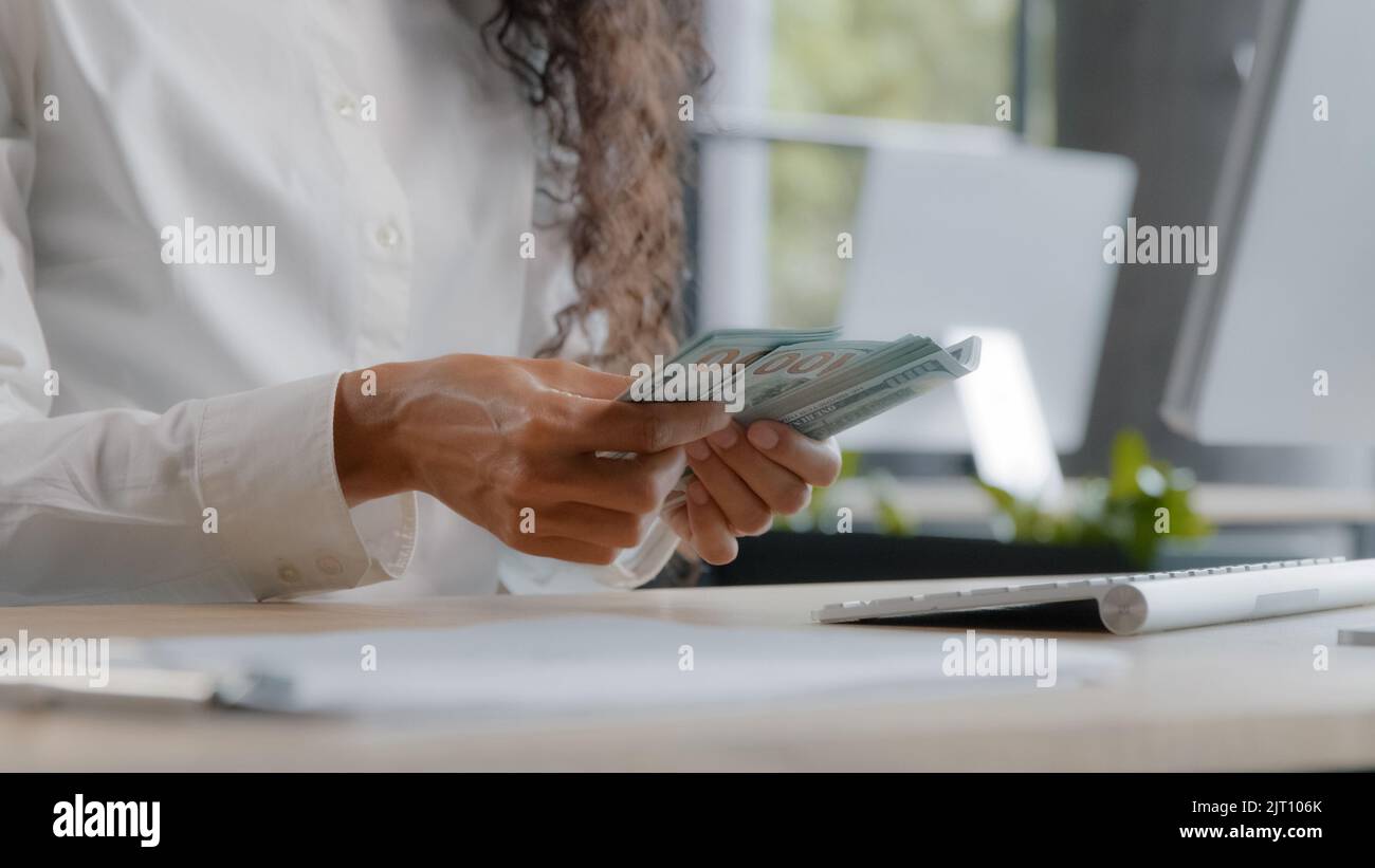 Une jeune femme comptable méconnaissable compte de l'argent sur le lieu de travail une employée de bureau la banque caissière calcule le salaire avec des factures en dollars papier chaque mois Banque D'Images