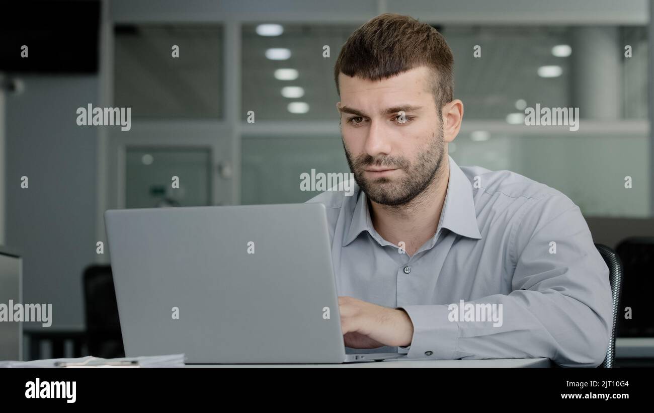 Homme d'affaires sérieux et concentré travaillant sur un ordinateur portable communiquant avec un collègue par vidéoconférence discutant du plan de travail du directeur de bureau professionnel Banque D'Images
