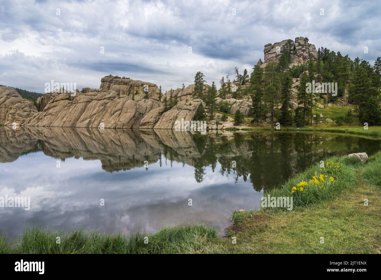 Les nuages de tempête d'été menacent d'effacer un reflet parfait des rives en granit du lac Sylvan dans les Black Hills du Dakota du Sud Banque D'Images