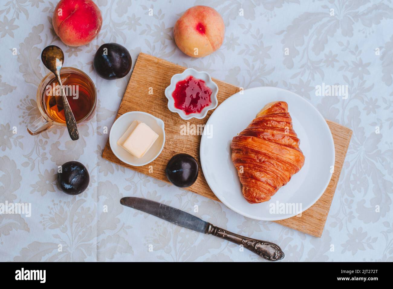 Croissant avec thé et confiture pour le petit déjeuner Banque D'Images