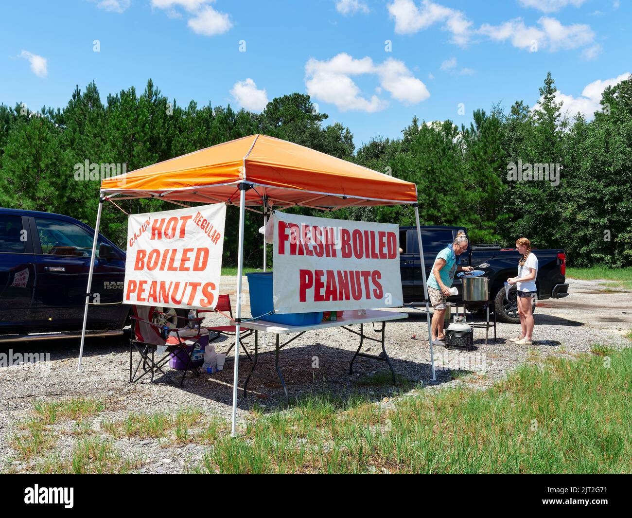 Femme et fille vendant d'un stand d'arachide frais chaud, à un client comme une entreprise de bord de route à Montgomery Alabama, États-Unis. Banque D'Images