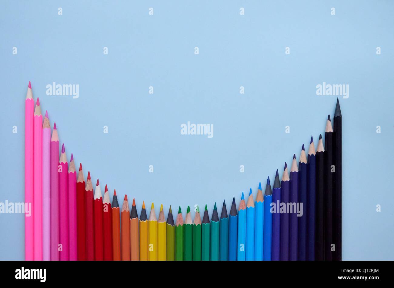 De nombreux crayons de couleur ondulés sur fond gris, platlay. Retour à l'école Banque D'Images