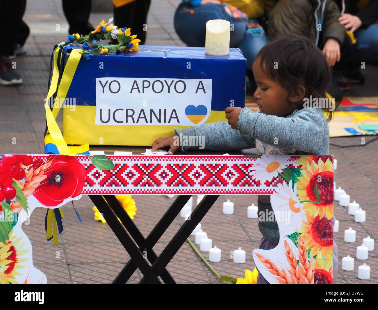 Un petit enfant péruvien indigène laisse une contribution dans une banque de pigey qui dit "je soutiens l'Ukraine" quand des résidents ukrainiens au Pérou et des sympathisants manifestent dans les rues de Lima contre la guerre russe contre l'Ukraine dans le cadre des activités pour le 31st anniversaire de l'indépendance de l'Ukraine. Banque D'Images