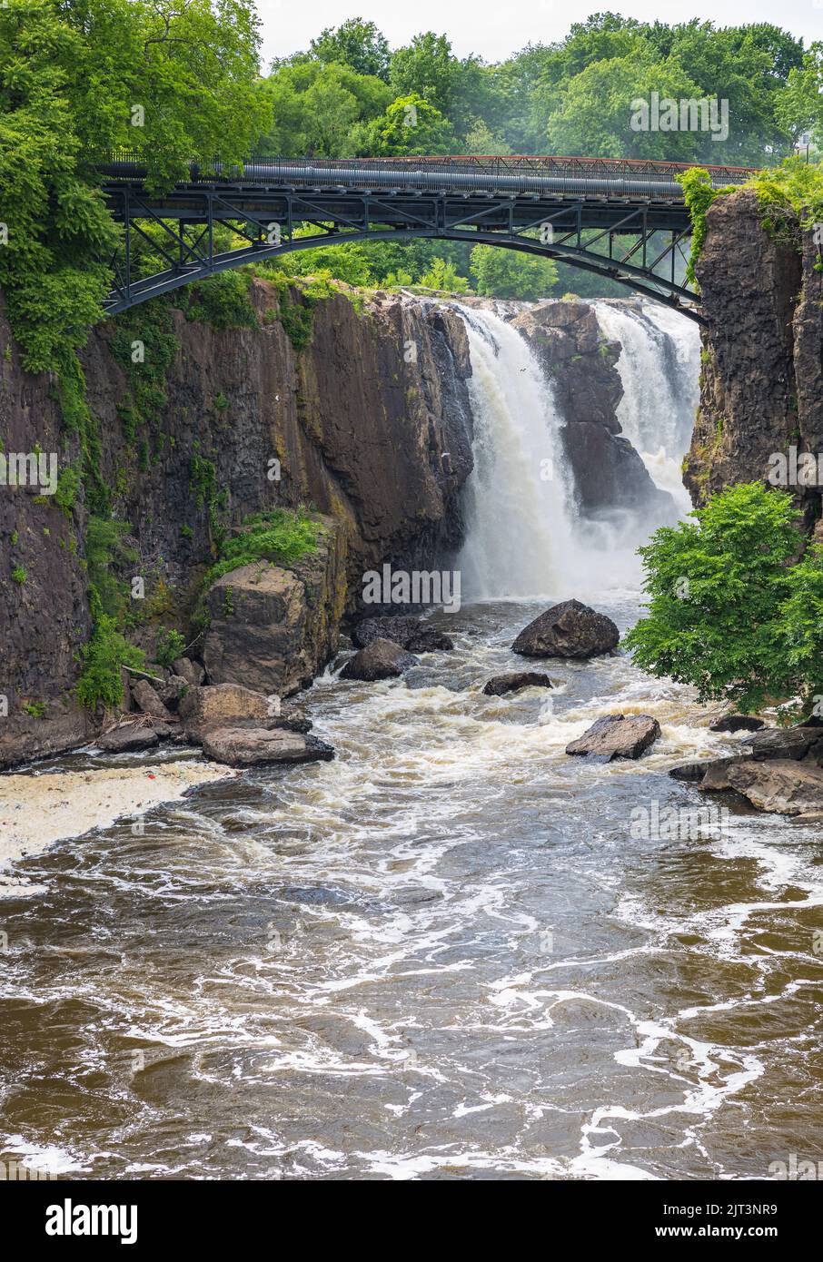 Une vue magnifique sur le parc historique national de Paterson Great Falls avec un pont sur l'eau coulant entourée d'une végétation luxuriante Banque D'Images