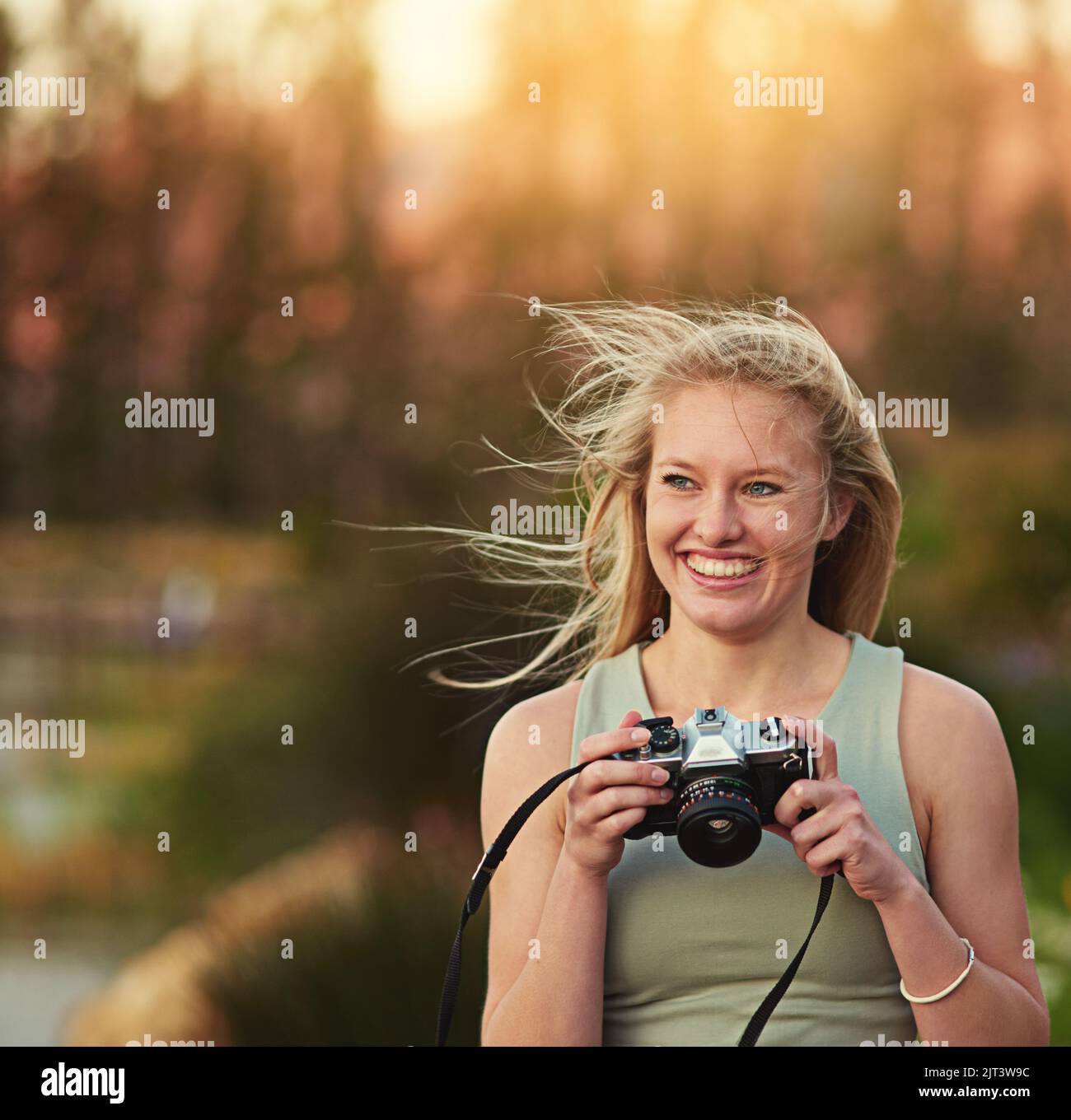 Une jeune femme prend des photos sur son appareil photo à l'extérieur. Banque D'Images