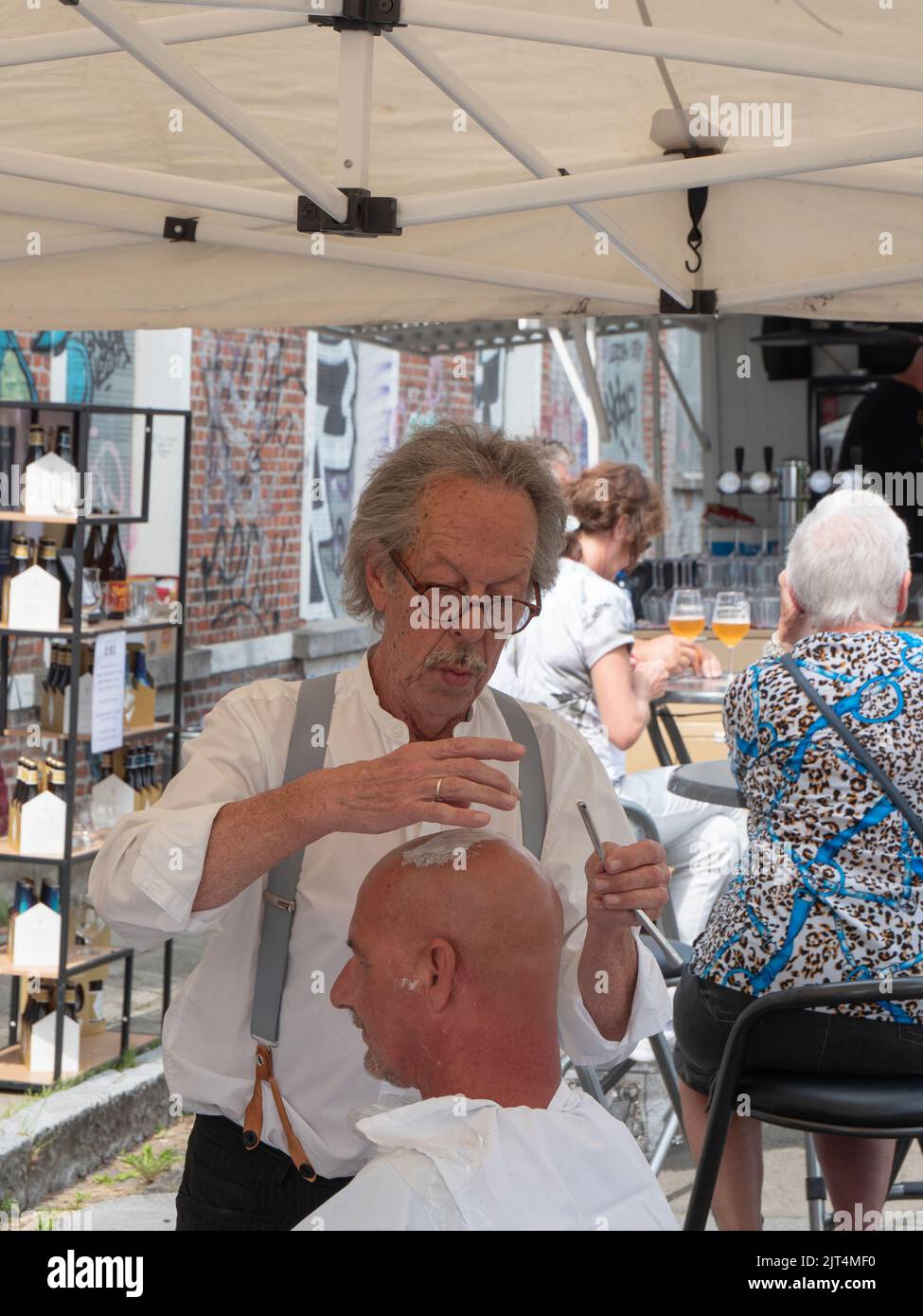 Sint Gillis Waas, Belgique, 21 août 2022, portrait d'un barbier âgé qui se raser la tête d'un homme Banque D'Images