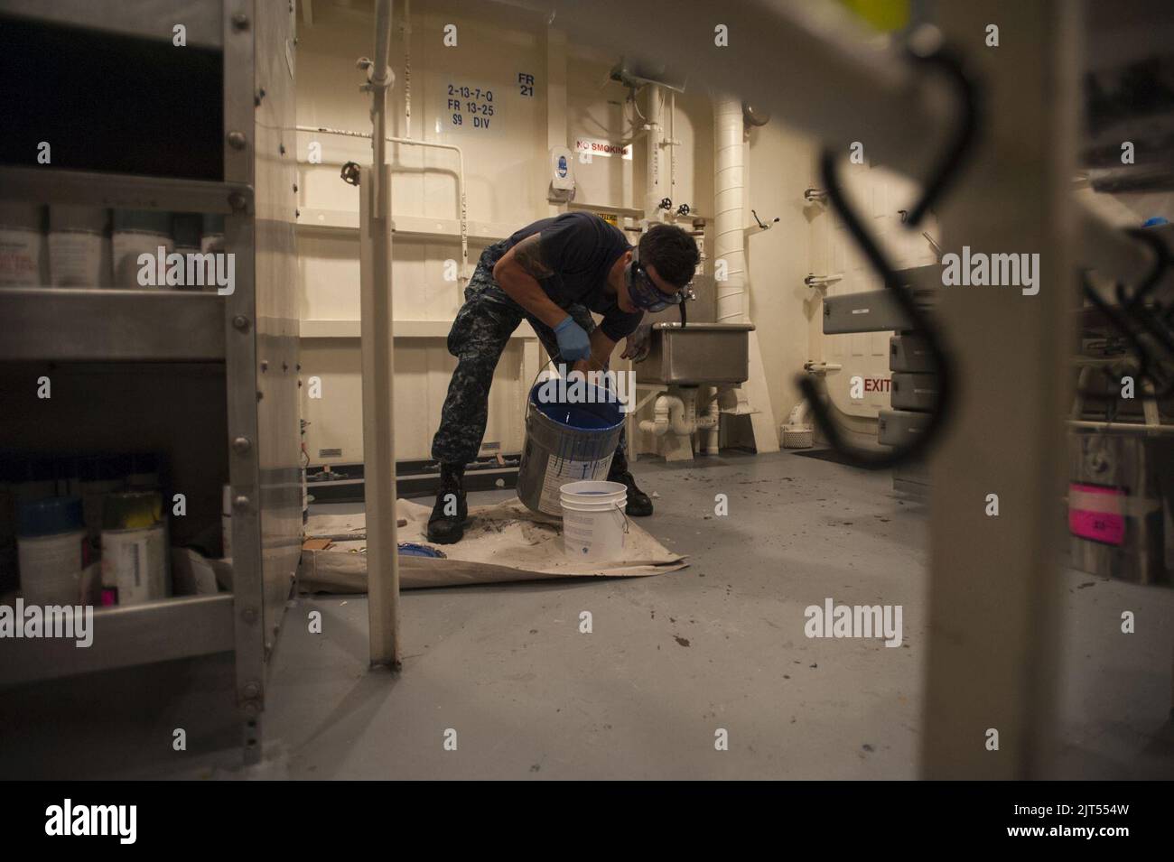Airman, technicien en équipement de soutien à l'aviation de la Marine américaine, verse la peinture d'un seau de 5 gallons dans un conteneur plus petit à bord du navire d'assaut amphibie USS America (LHA 6) sept 140905 Banque D'Images