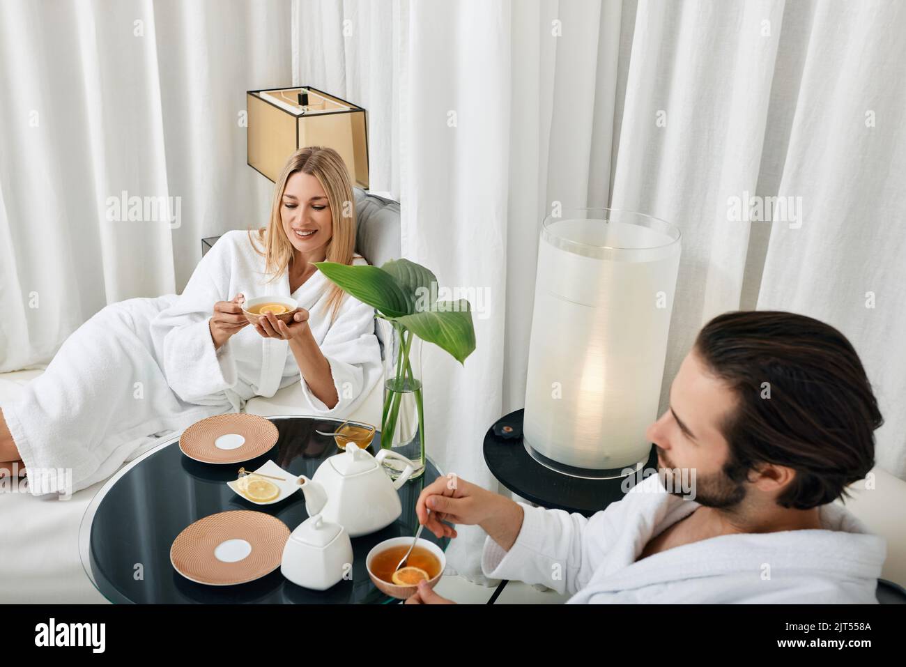 Couple pendant un week-end romantique. Un jeune couple aimant dans des peignoirs blancs, passant du temps au spa et prenant un thé de guérison Banque D'Images