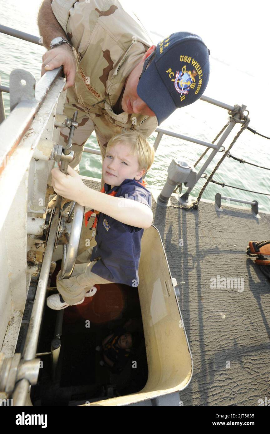 U.S. Navy Lt. Top, l'officier exécutif du navire de patrouille côtière USS Whirlwind (PC 11), aide un scout de Cub hors d'une trappe lors d'une visite du navire à la jetée de Mina Salman, Manama, Bahreïn, le 7 120107 janvier Banque D'Images