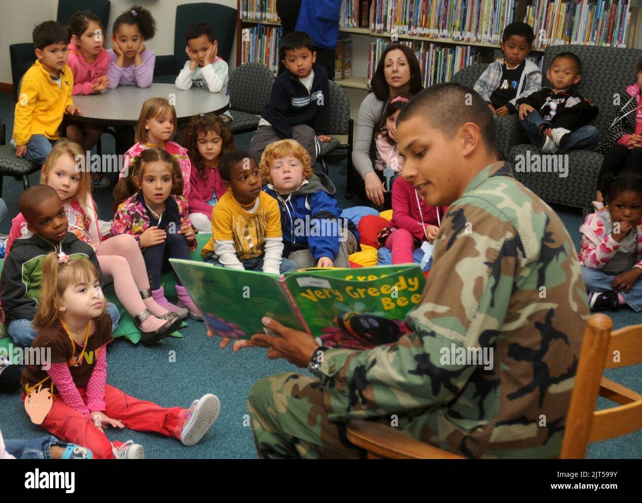 US Navy Utitiesman Constructionman Jordan Delasalas, premier plan, un Seabee affecté au bataillon de construction mobile navale 74, lit aux enfants de la bibliothèque de la base navale de Rota, Espagne, 30 mars 2011 110330 Banque D'Images