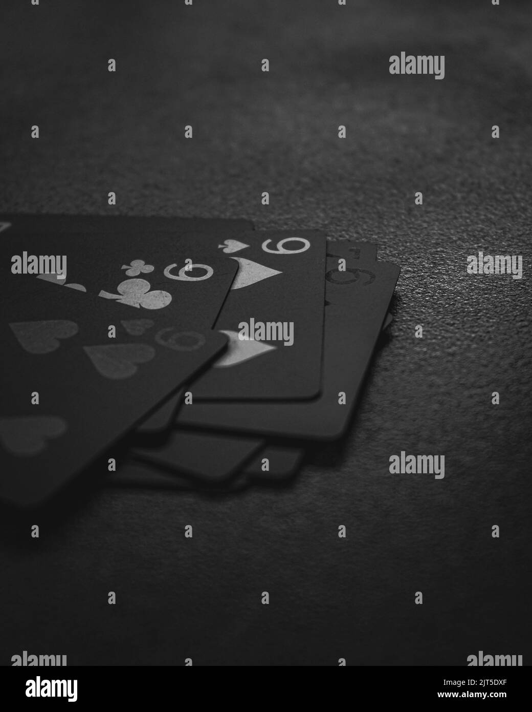 Image verticale en niveaux de gris de cartes à jouer noires Banque D'Images