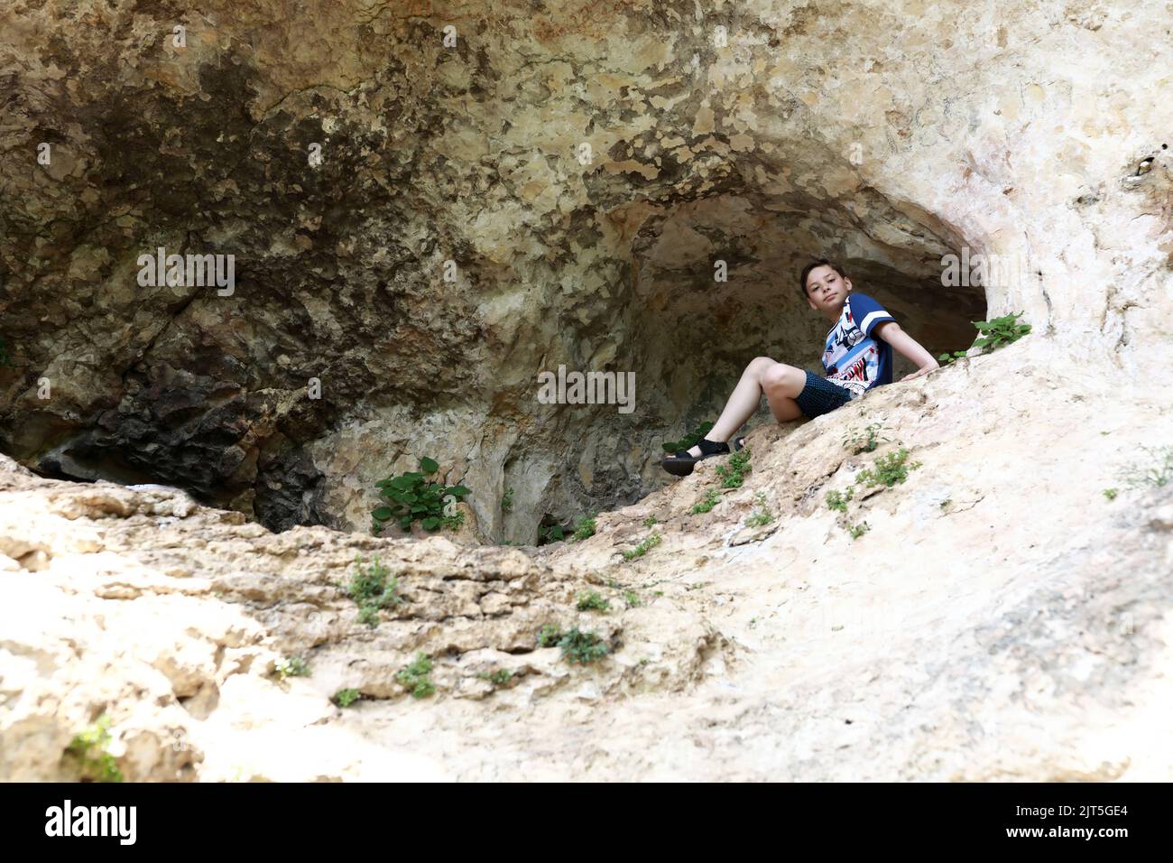 Enfant assis dans une grotte sur una-Koz Ridge, Adygea Banque D'Images