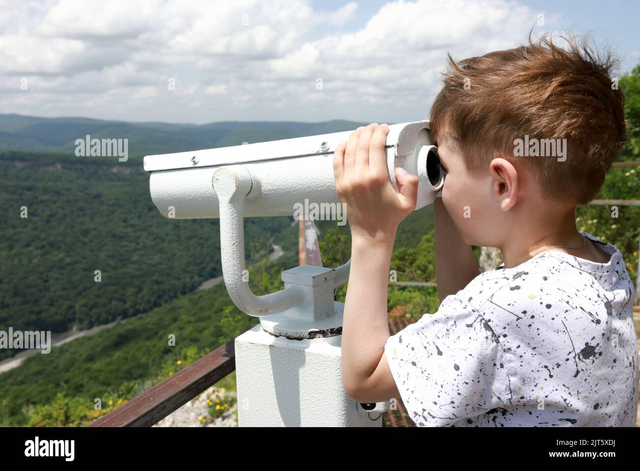 L'enfant regarde à travers des jumelles dans la vallée de la rivière Belaya depuis la crête d'una-koz, Adygea Banque D'Images