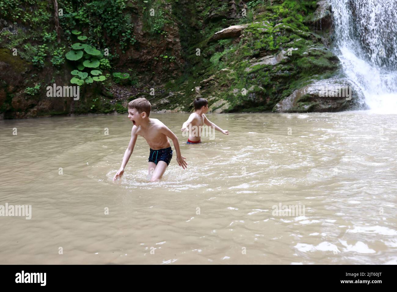 Frères se baignant dans le ruisseau Rufabrigo à côté de la chute d'eau Shum, Adygea Banque D'Images