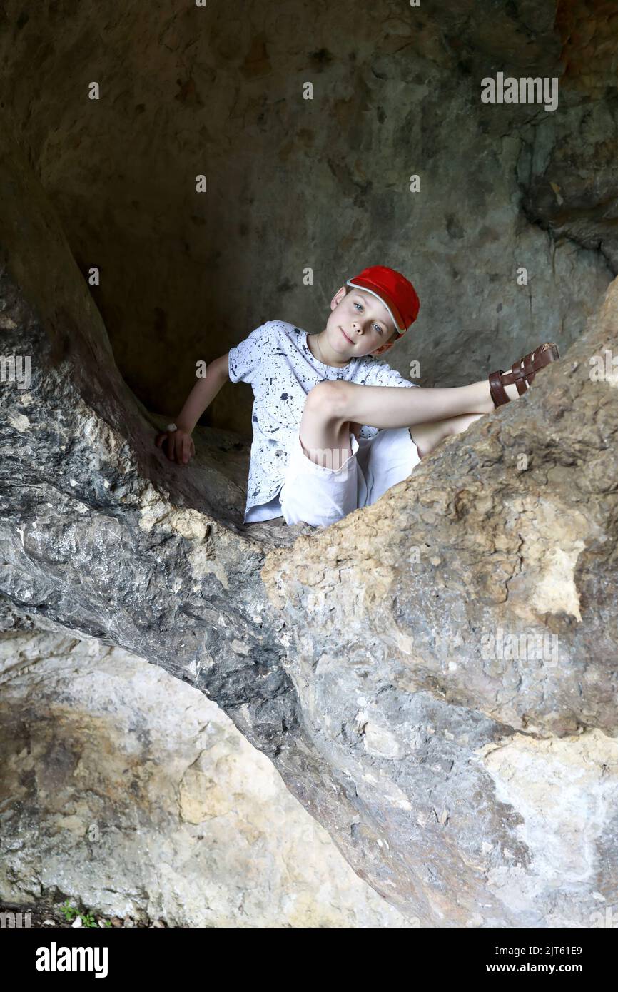 Garçon assis dans une grotte sur una-Koz Ridge, Adygea Banque D'Images