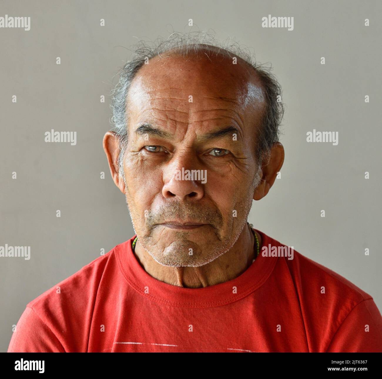 Portrait d'un homme hispanique âgé contre un mur blanc Banque D'Images