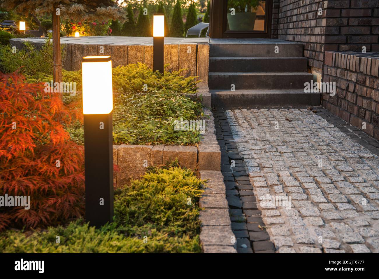 Poteaux de lumière LED de cour le long du chemin du jardin. Illuminez les paysages grâce aux systèmes d'éclairage extérieur modernes. Banque D'Images